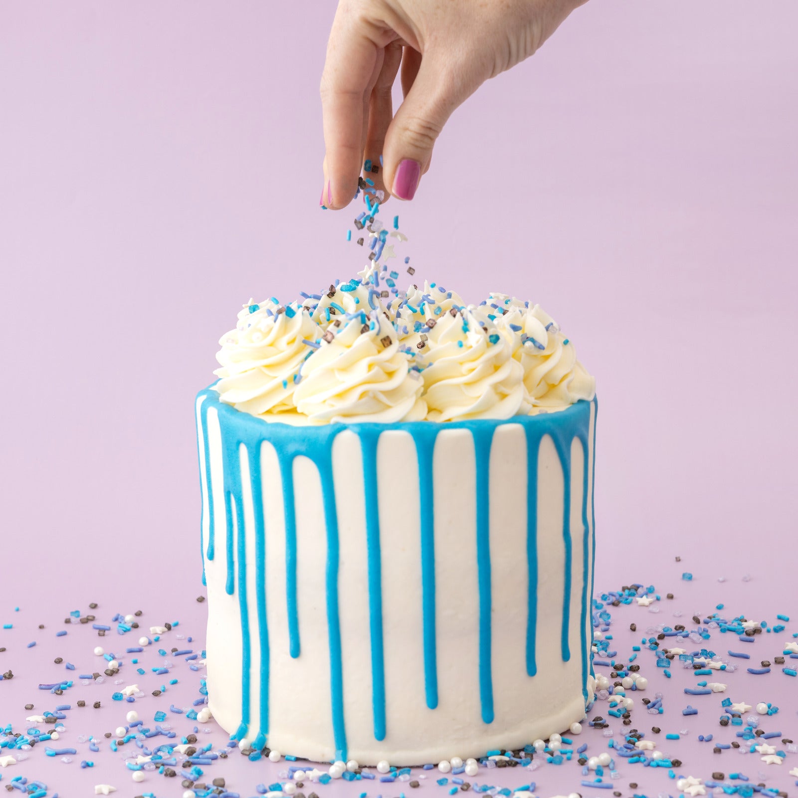 White cake with blue Sweetshop Cake Drip being used on cake