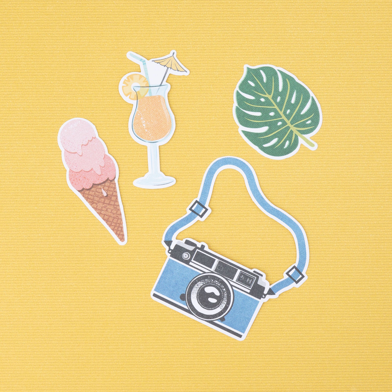 Close up of a few pieces from the American Crafts Vicki Boutin Where to Next Ephemera Icon Die Cut Shapes - 50 Piece on yellow background