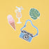 Close up of a few pieces from the American Crafts Vicki Boutin Where to Next Ephemera Icon Die Cut Shapes - 50 Piece on yellow background