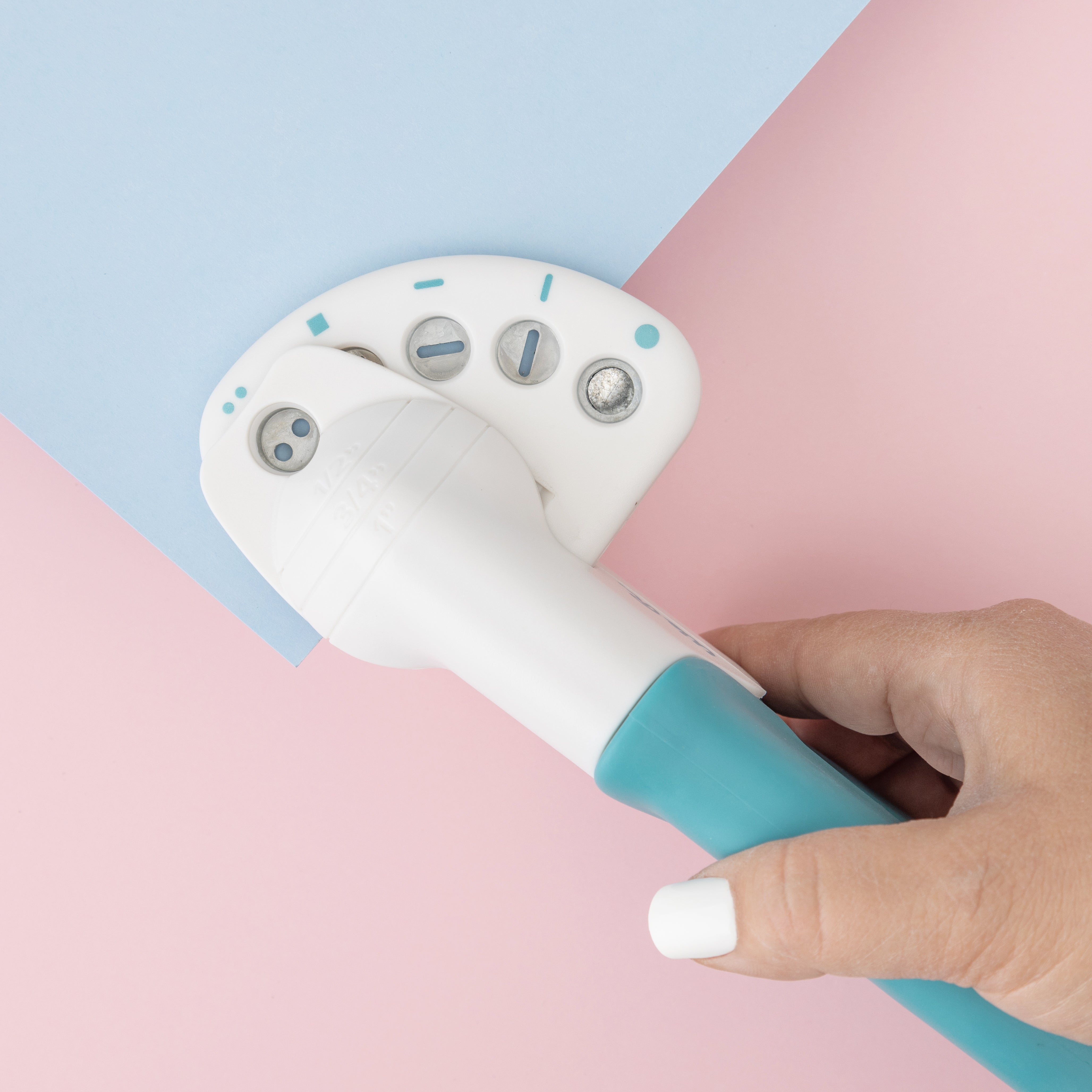 Lifestyle image of We R Makers Crop-A-Dile Functional Multi Hole Power Punch being used on craft paper