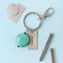 Lifestyle images of keychain with jewelry piece that is stamped