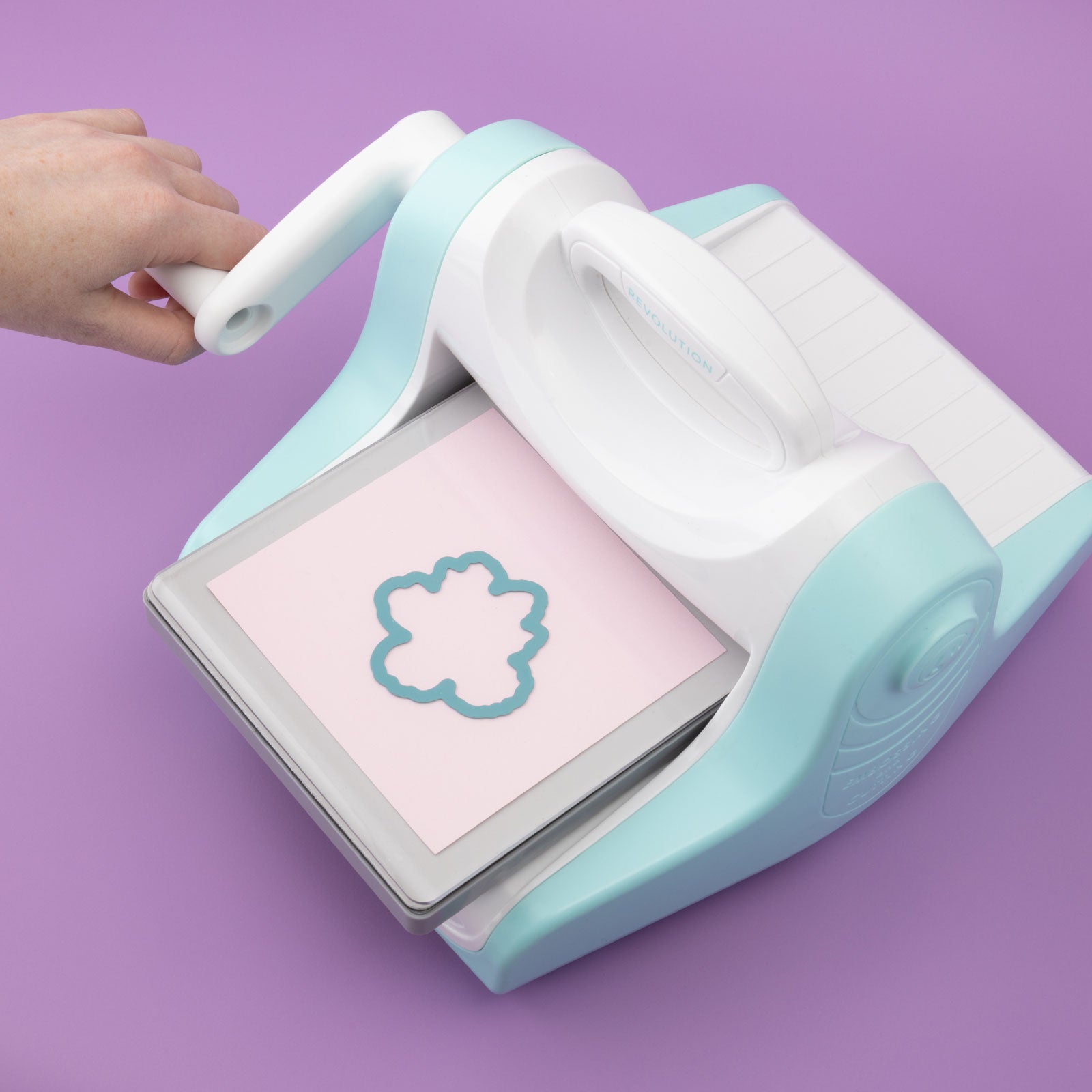 Lifestyle image of We R Makers Revolution Die Cutting Replacement Plate being used to die cut in the Revolution Die Cutter