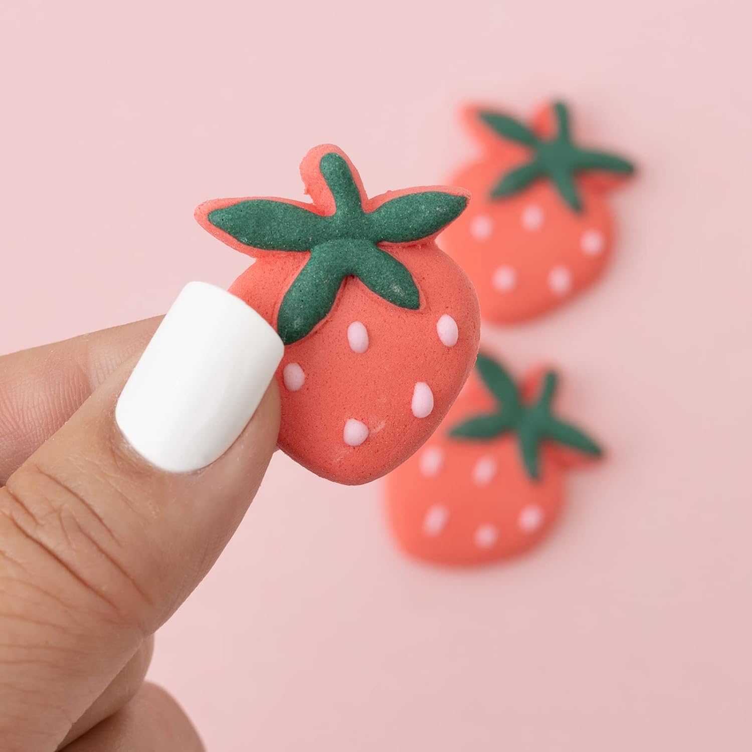 Close up image of the Sweetshop Strawberry Icing Decoration being held