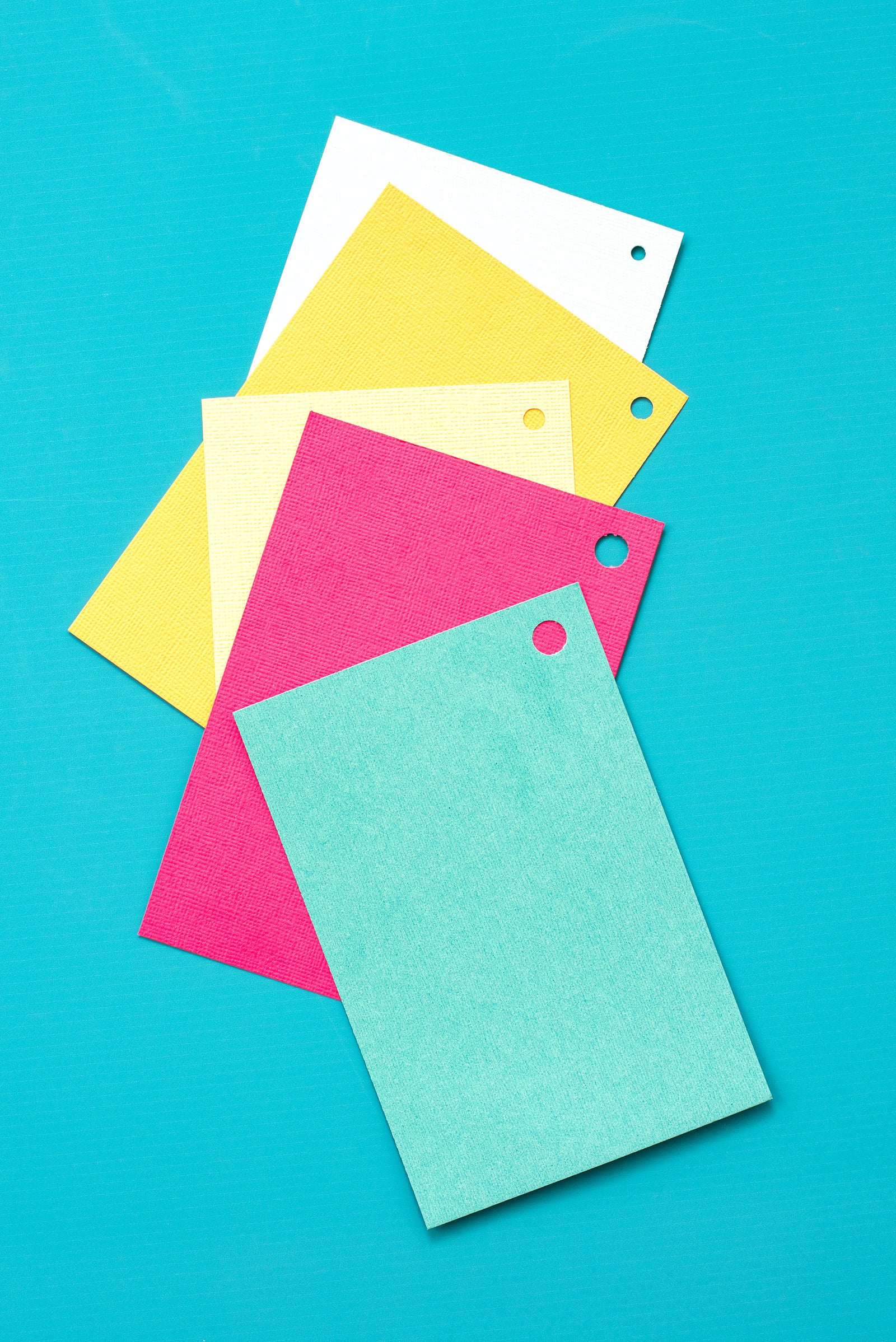 Sheets of craft paper that have hole punches by the We R Makers Crop-A-Dile Circle Multi Hole Punch