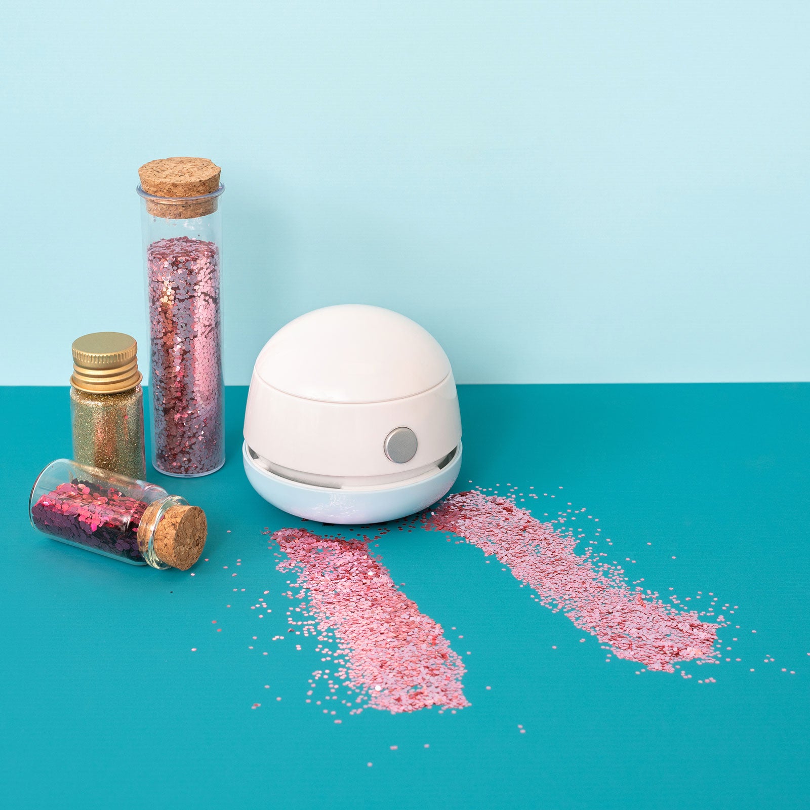 Lifestyle image of the We R Makers Glitter Mini-Vac vacuuming glitter 