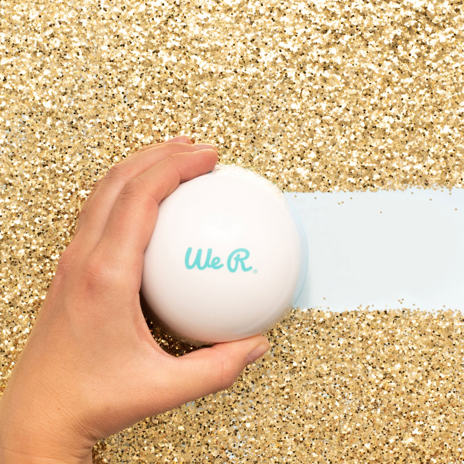 Lifestyle of We R Makers Glitter Mini-Vac being used to vacuum gold glitter