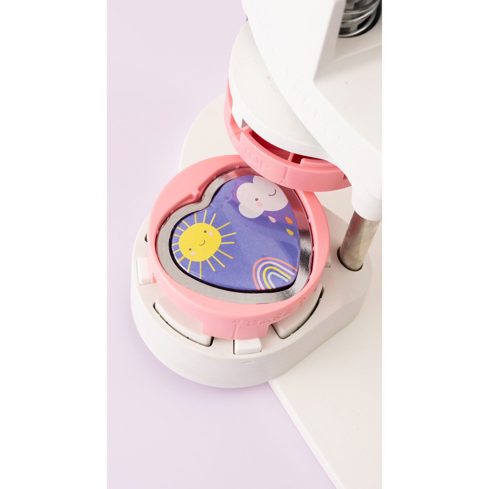 Lifestyle image of heart shaped button in heart insert in button press