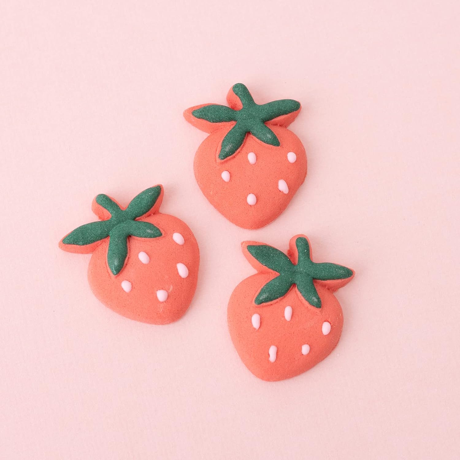 Three Sweetshop Strawberry Icing Decorations on pink background