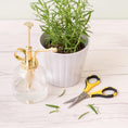 Load image into Gallery viewer, EK Tools Cutter Bee Small Precision Scissors next to a potted plant.
