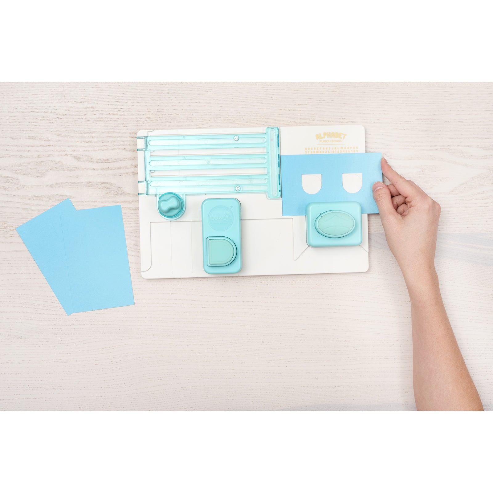 Image of a person using the We R Makers Alphabet Punch Board for a craft.