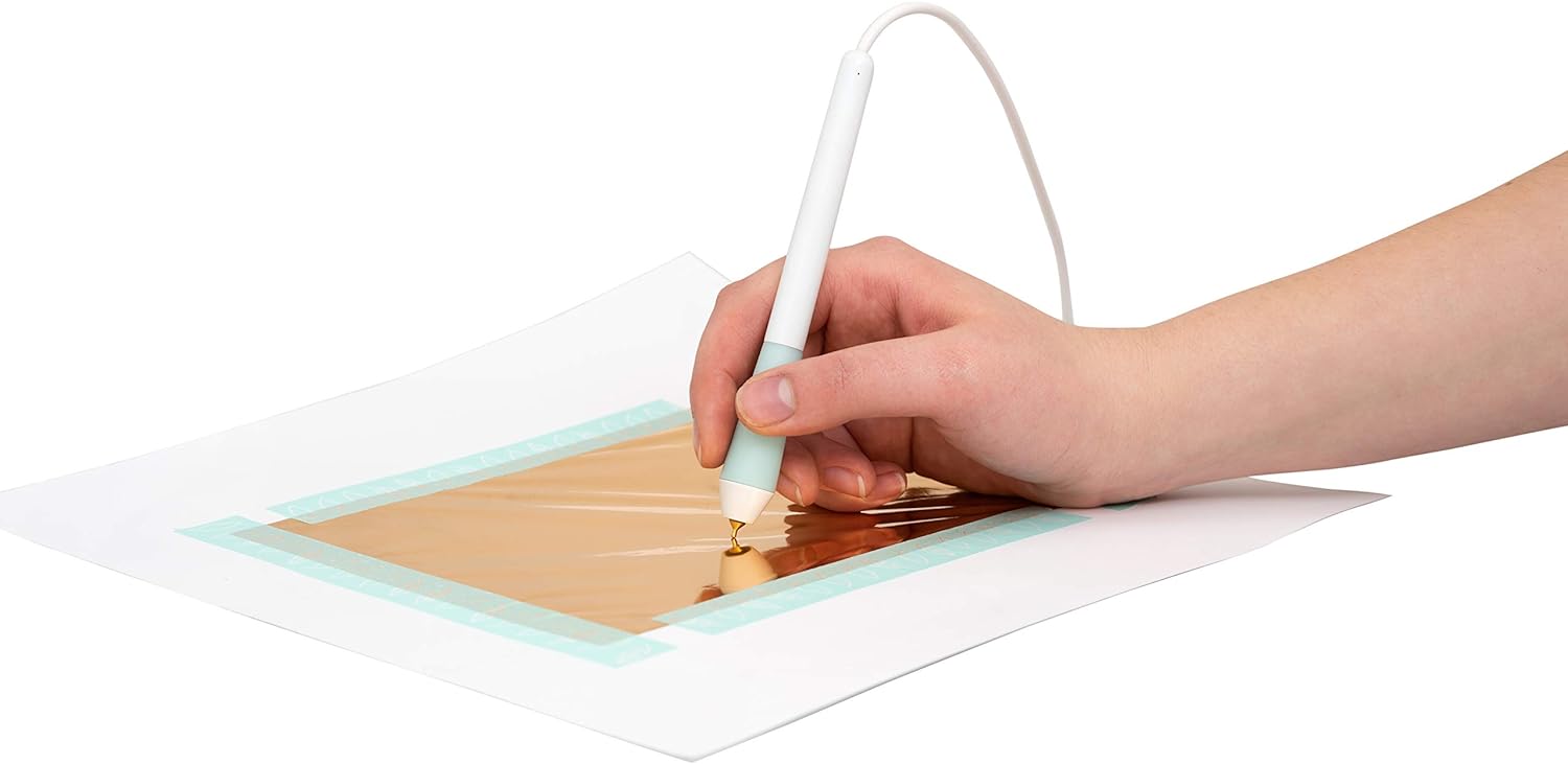  A person using the We R Makers Foil Quill Fine Tip Freestyle Pen for a craft.