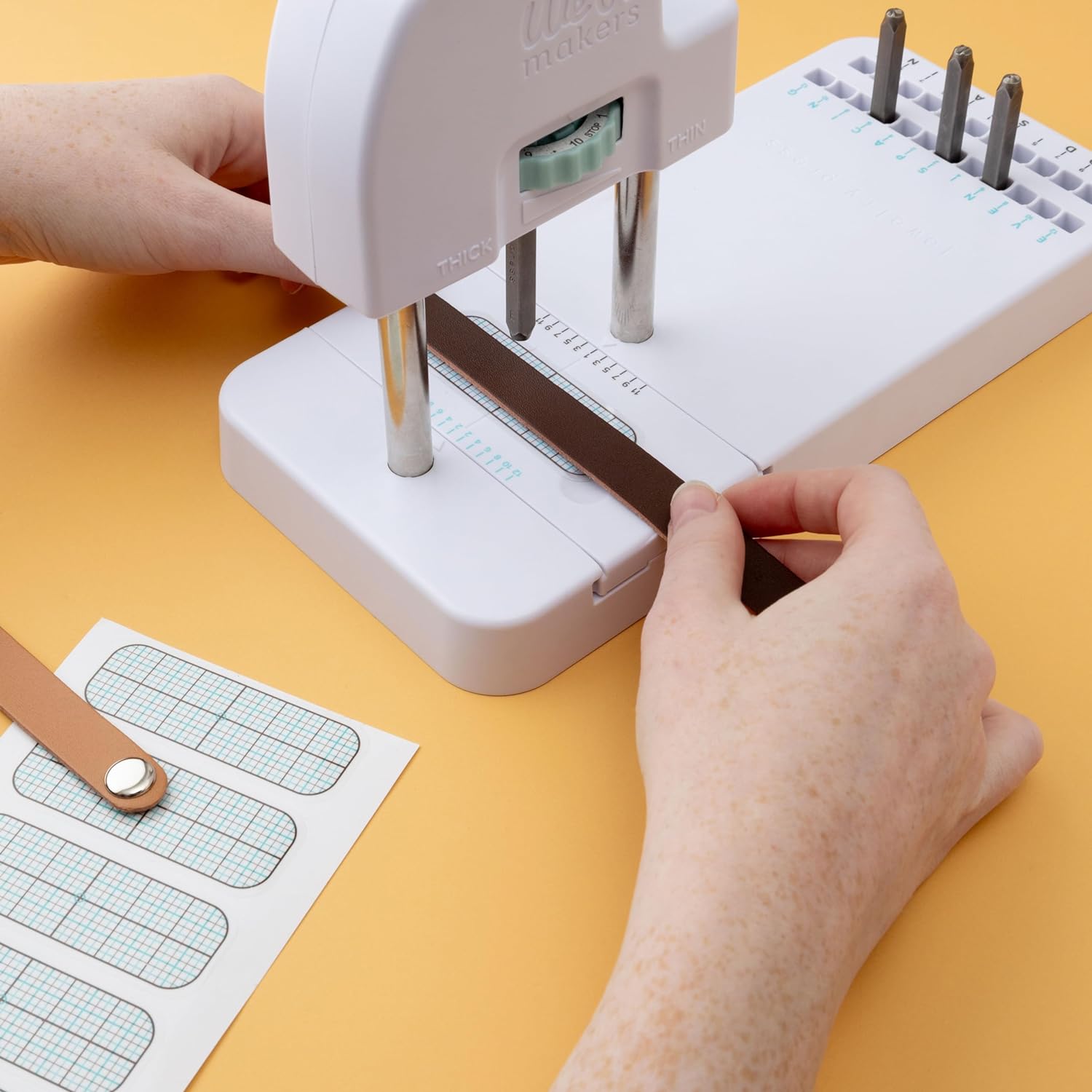 Image of a person using the We R Makers Jewelry Press Kit Machine to create a project.