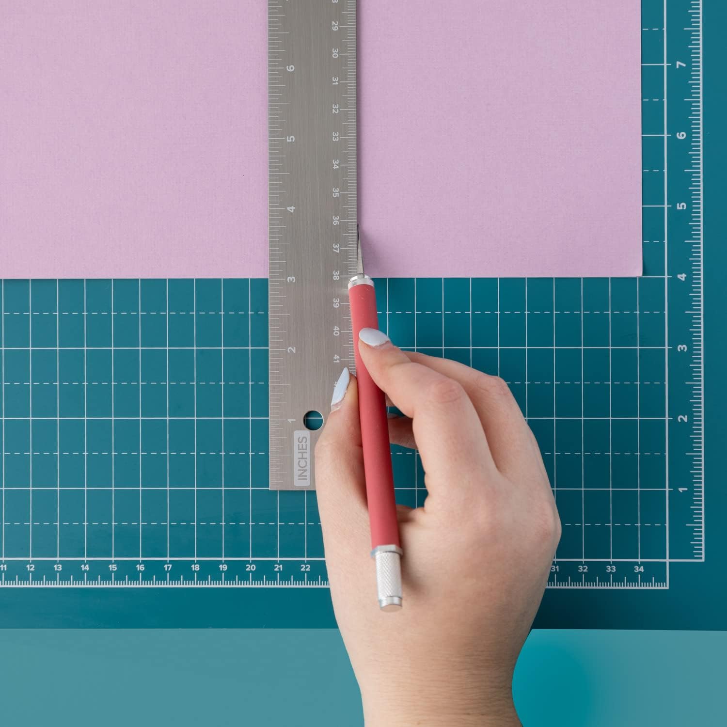 Image of a person using the We R Makers Large 18x14 Magnetic Mat to cut paper.
