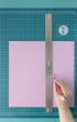 Picture of a person using the We R Makers Large 18x14 Magnetic Mat to draw a line with a ruler.