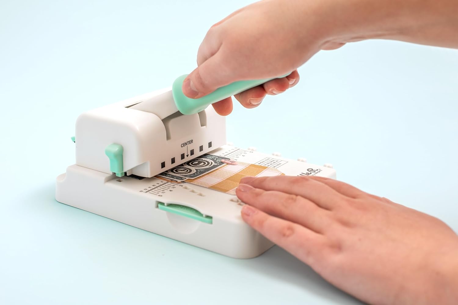 Lifestyle image of We R Makers Mini Cinch Book Binding Machine being used from the side