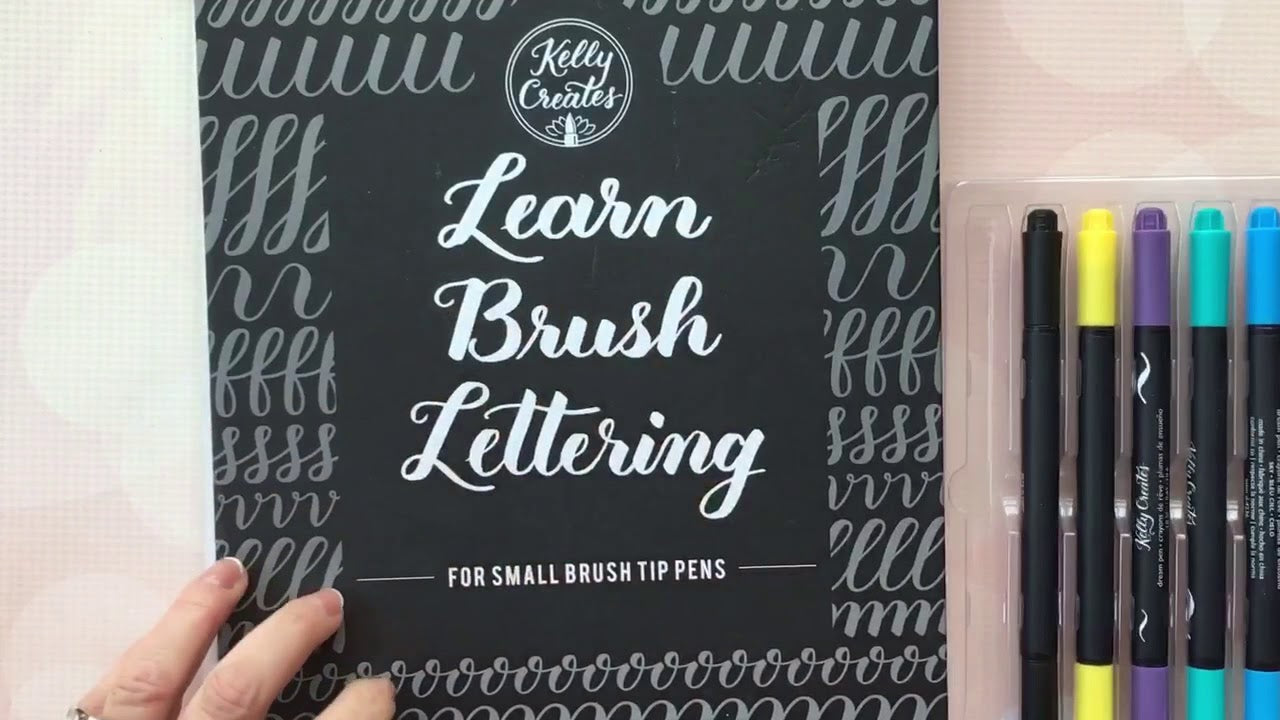 Load video: Look inside the Kelly Creates brush lettering workbooks. I explain how to use the workbook with the Dream Pens and Small Brush tip pens and how to practice in the Lined Practice pad.